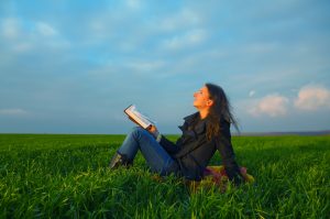 Teen girl reading the Bible outdoors