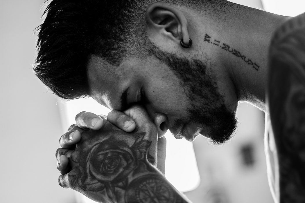 Tattooed man praying