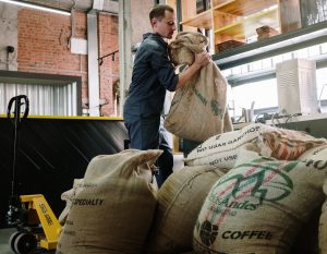 Man working to move coffee bag